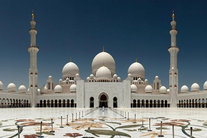 The stunning Sheikh Zayed Grand Mosque showcases intricate architecture and peaceful surroundings inviting travelers to explore its majestic domes vast courtyards and detailed artistry in a serene setting.